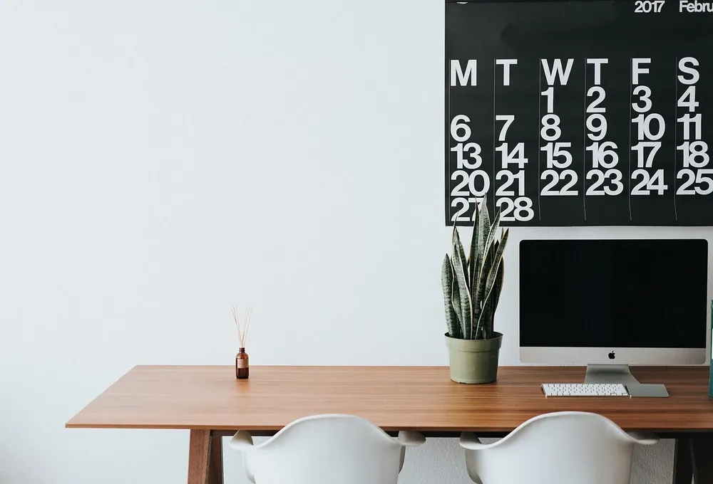 A tidied desk with the monitor, plant and calendar put back in place